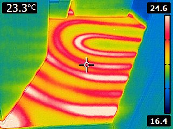 Původní termosnímek prohřívání podlahy s viditelnou trasou topného potrubí a teplotní stupnicí