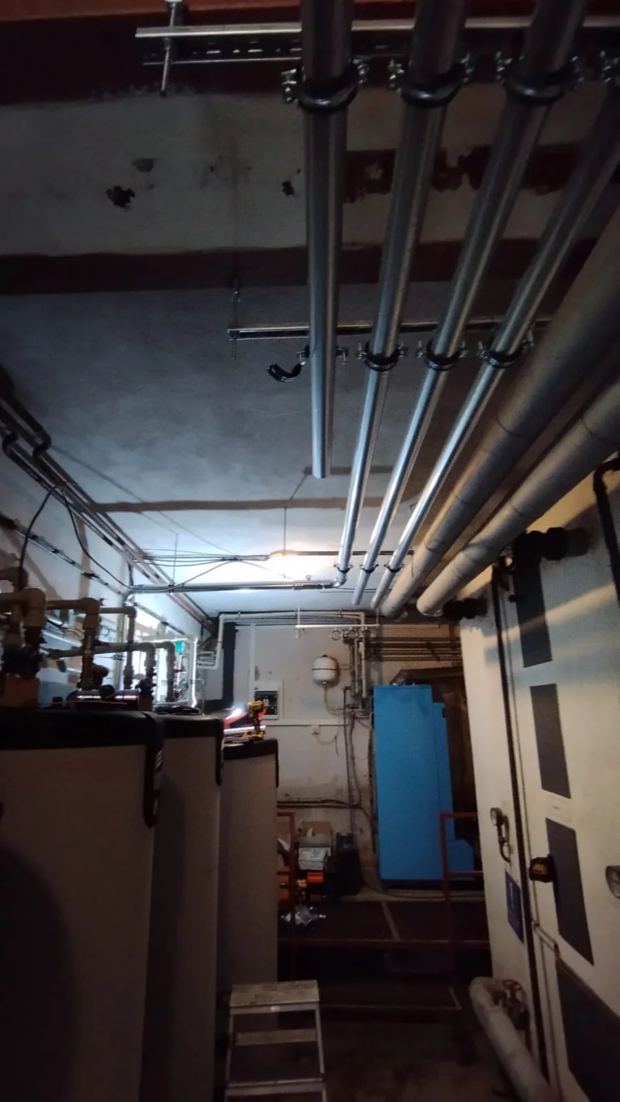 Potkávárna u Havrana. Montáž nových tras potrubí pod stropem.